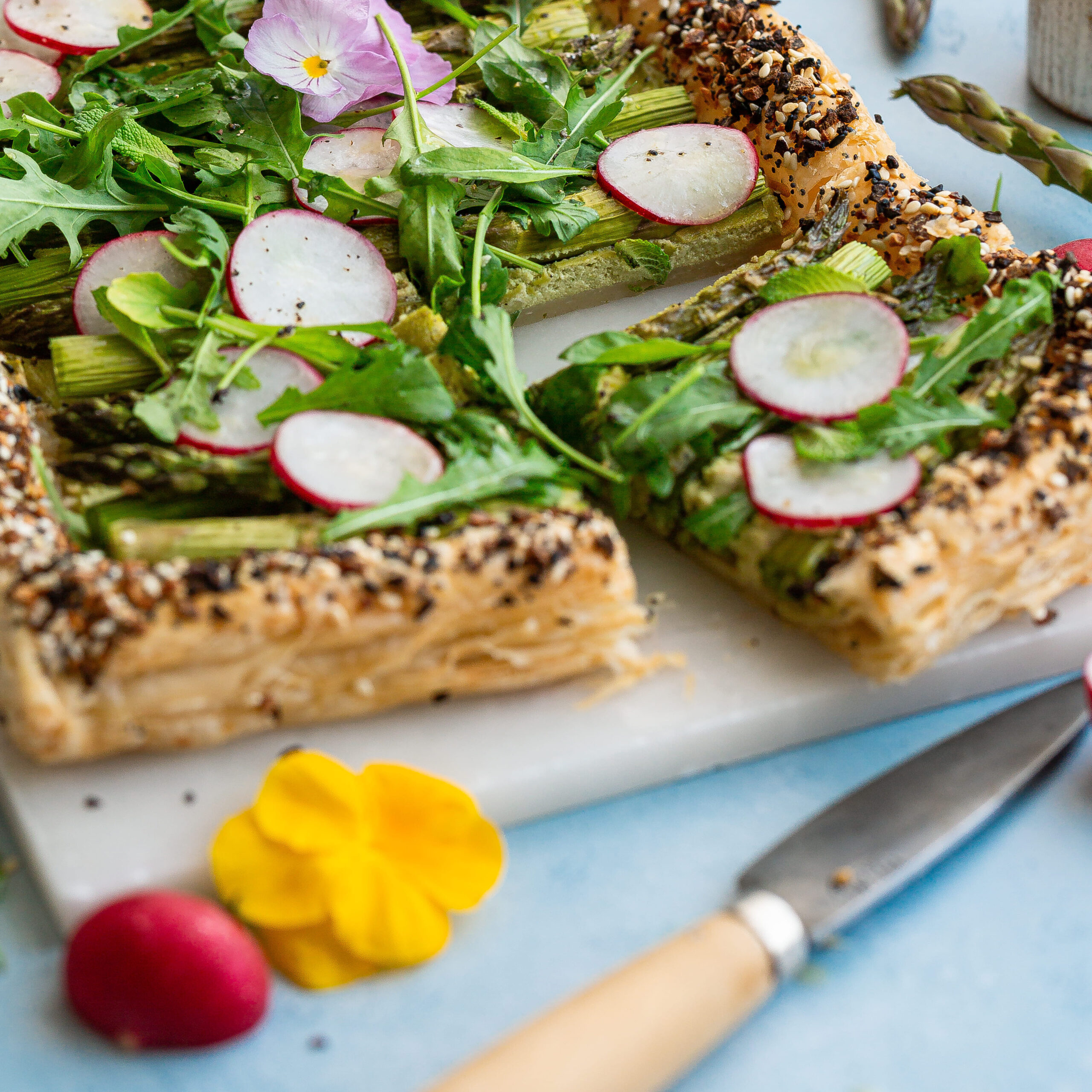 Sluoksniuotos tešlos tarta su smidrais, ridikėliais, šviežiais žalumynais, pertepta pesto kremu.